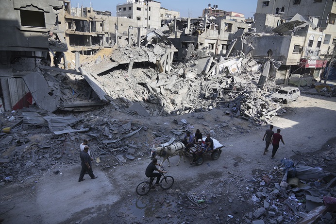 Palestinos/as pasan por la destrucción causada por el bombardeo israelí de la Franja de Gaza en el campo de refugiados/as de Maghazi el 3 de noviembre. El Concilio Metodista Unido de Obispos/as emitió una declaración sobre el conflicto entre Israel y Gaza en medio de crecientes llamados internacionales para un alto el fuego. Los/as obispos/as pidieron oración y alentaron a trabajar por una paz duradera. Foto de AP/Hatem Moussa  Palestinos/as pasan por la destrucción causada por el bombardeo israelí de la Franja de Gaza en el campo de refugiados/as de Maghazi el 3 de noviembre. El Concilio Metodista Unido de Obispos/as emitió una declaración sobre el conflicto entre Israel y Gaza en medio de crecientes llamados internacionales para un alto el fuego. Los/as obispos/as pidieron oración y alentaron a trabajar por una paz duradera. Foto de AP/Hatem Moussa