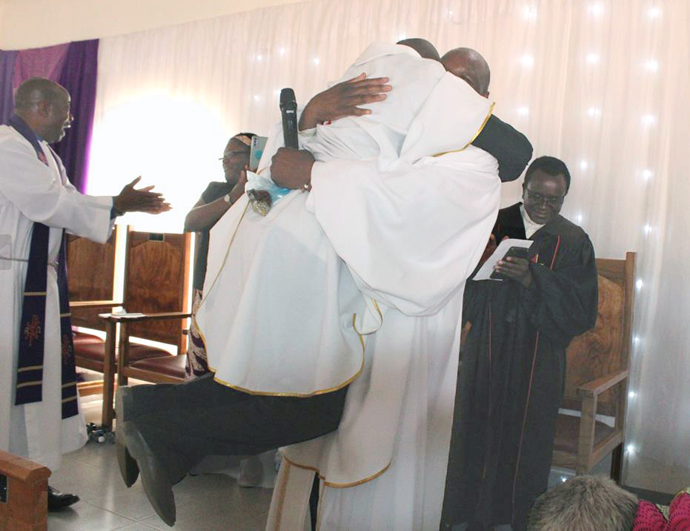 The Rev. Honesty Sithole, Chitenderano pastor-in-charge, leaps into the arms of the Rev. Lloyd Nyarota during a celebration of the church’s new sanctuary in Rusape, Zimbabwe, and the purchase of a new circuit vehicle. “I was filled with joy,” Sithole said. Photo by Kudzai Chingwe, UM News.