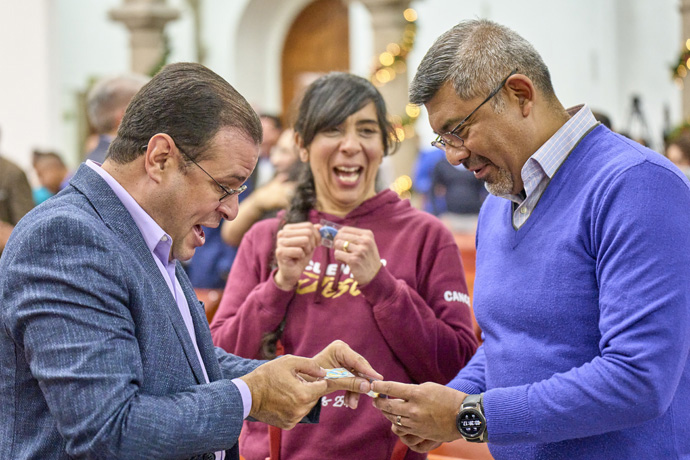 El obispo metodista unido Héctor A.  Burgos Núñez (izquierda) intercambia broches de solapa conmemorativos con el obispo metodista Rodolfo Edgar Rivera de la Rosa, presidente de la Conferencia Anual del Centro Norte de México, el 30 de noviembre de 2023, durante una conferencia en la Ciudad de México para conmemorar el 150 aniversario de la fundación de La Iglesia Metodista en México.  Observando el intercambio está la Reverenda Cynthia Carrillo, esposa del obispo Rivera de la Rosa.  Foto de Paul Jeffrey, Noticias de la UM.