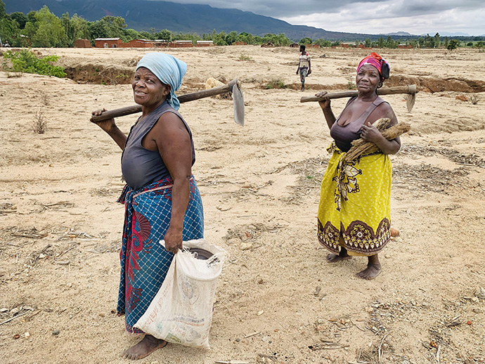 Zione Nechavava and Malita Ngozo, Cyclone Freddy survivors from Nkhulambe, return from their vegetable garden after planting seeds supplied by The United Methodist Church in Malawi. The church is providing agricultural training and equipment and helping reconstruct community infrastructure with a $50,000 grant from the United Methodist Committee on Relief. Photo by Francis Nkhoma, UM News.