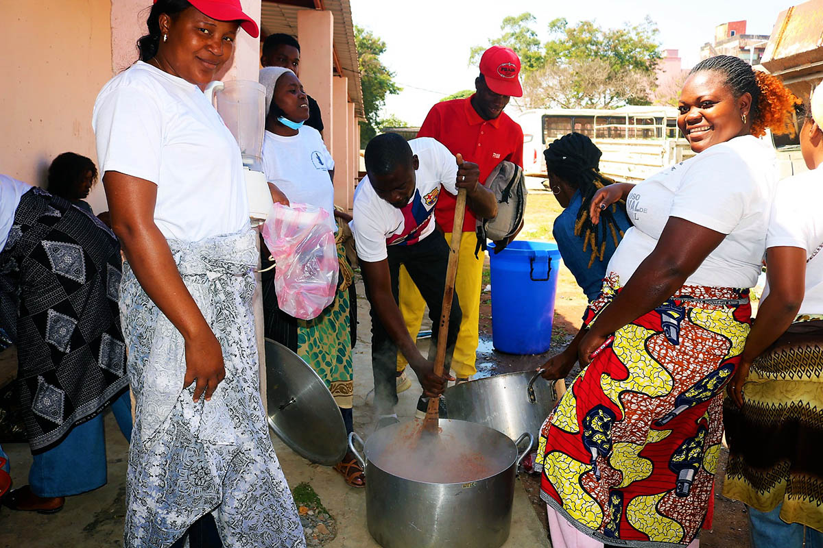 Irmão André Francisco Tungo rodeado de outros Jovens Adultos prepara o purê de feijão para sopa solidária. Malanje, foto de João Nhanga.
