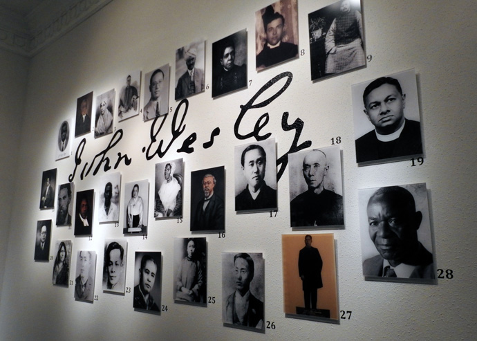 Photos of 28 Methodist history-making leaders from around the world are grouped around an enlarged replica of John Wesley’s signature. The display is part of the World Methodist Museum Collections at Perkins School of Theology’s Bridwell Library. Photo by Sam Hodges, UM News.