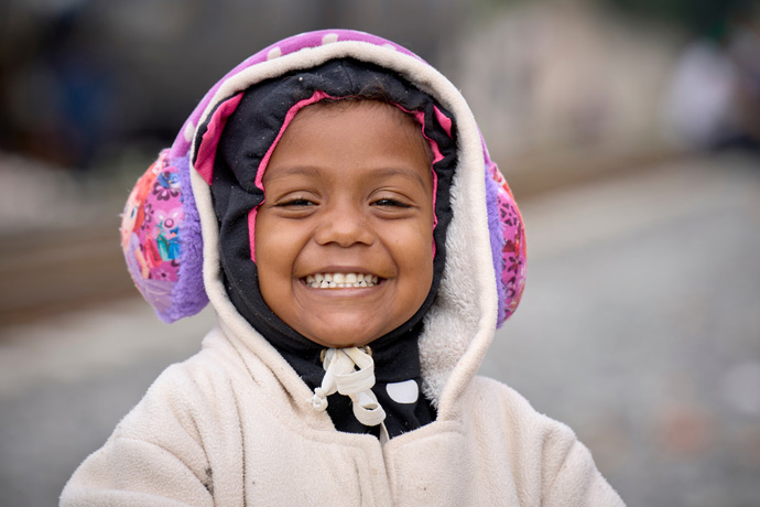 After spending the night sleeping beside the railroad tracks in Apaxco, Mexico, 3-year old Ari Angeli smiles as she faces another day waiting for a train. From Venezuela, she has been traveling with her mother for a month. They've spent two days in Apaxco waiting for a freight train to stop so they can climb aboard. Photo by the Rev. Paul Jeffrey, UM News.