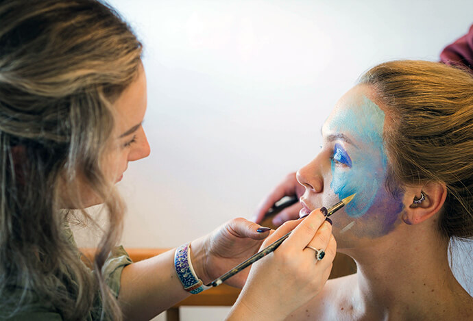 A woman has her face painted for a photography exhibition during a retreat to help cope with trauma from the war in Ukraine. Photo courtesy of the Faces of Courage Facebook page.