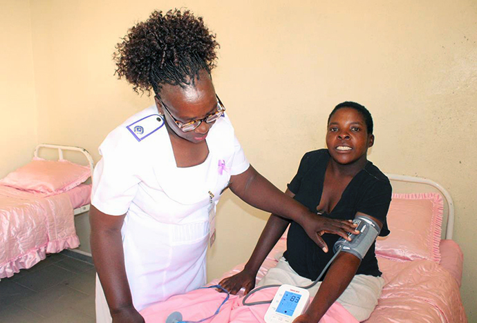 Sister-in-Charge Mildred Marimbire encourages Kudzai Chimwamwa to relax while taking her blood pressure at The United Methodist Church’s Munyarari Mission Clinic in Munyarari, Zimbabwe. Expectant mother Chimwamwa, who lives about 5 miles away, is staying at the new waiting mother’s shelter at the clinic. Photo by Kudzai Chingwe, UM News.