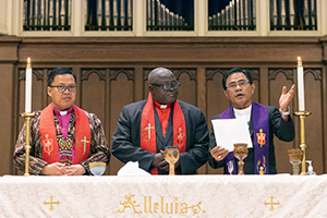 United Methodist bishops bless the elements of Holy Communion during a global worship service at First United Methodist Church in Charlotte, North Carolina, in the run-up to the 2024 United Methodist General Conference. From left to right are the bishops Israel Maestrado Painit of the Philippines, John Wesley Yohanna of Nigeria and Rodolfo A. Juan of the Philippines.  The meeting was coordinated by the Love Your Neighbor Coalition and the National Association of Filipino American United Methodists.  Photo by Mike DuBose, UM News.