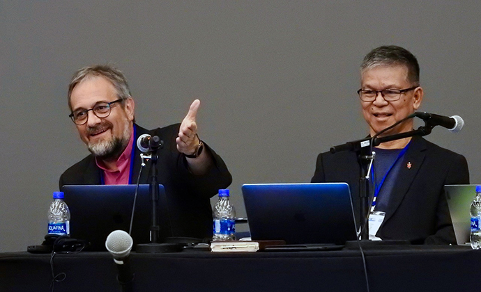 Bishop Harald Rückert and retired Bishop Ciriaco Francisco enjoy a light moment during an April 21 meeting of the Standing Committee on Central Conference Matters in Charlotte, N.C. The bishops shared in presiding over the meeting, which dealt with a range of petitions submitted to General Conference. Photo by Sam Hodges, UM News.