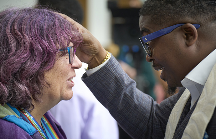 The Rev. Ron Bell (right) anoints with oil a participant at the United Methodist General Conference in Charlotte, N.C. Bell, director of healing and resilience for Discipleship Ministries and The Upper Room, participated in an April 26 noontime communion service near a prayer center outside the gathering's legislative committee rooms. Photo by Paul Jeffrey, UM News.