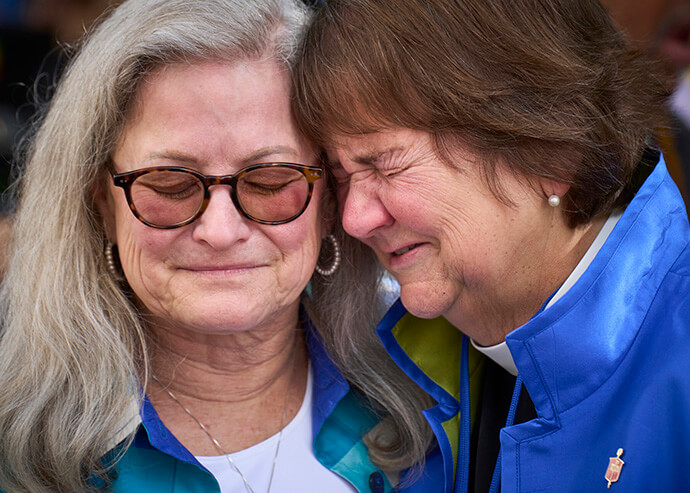 Bishop Karen Oliveto (right) and her wife, Robin Ridenour, react on May 1 after the United Methodist General Conference, meeting in Charlotte, N.C., voted to remove the denomination's ban on the ordination of clergy who are “self-avowed practicing homosexuals.” Photo by Paul Jeffrey, UM News.