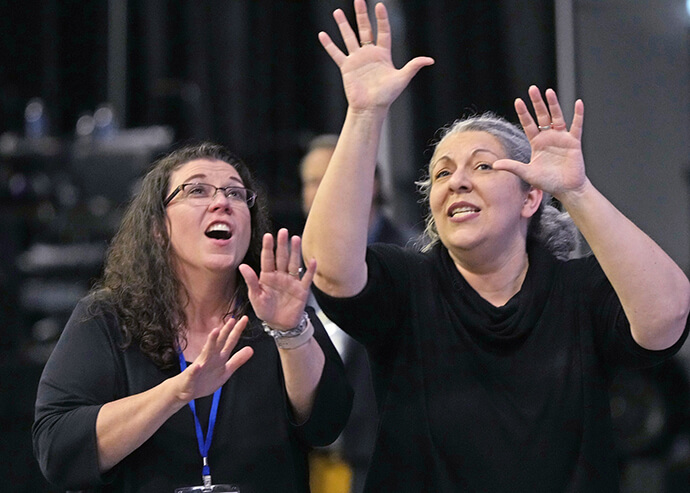 Sign-language interpreters Andrea Raye (left) and Tina McDaniel sing and dance to "Stand by Me" during a break on May 3 at the United Methodist General Conference in Charlotte, N.C. Photo by Larry McCormack, UM News.
