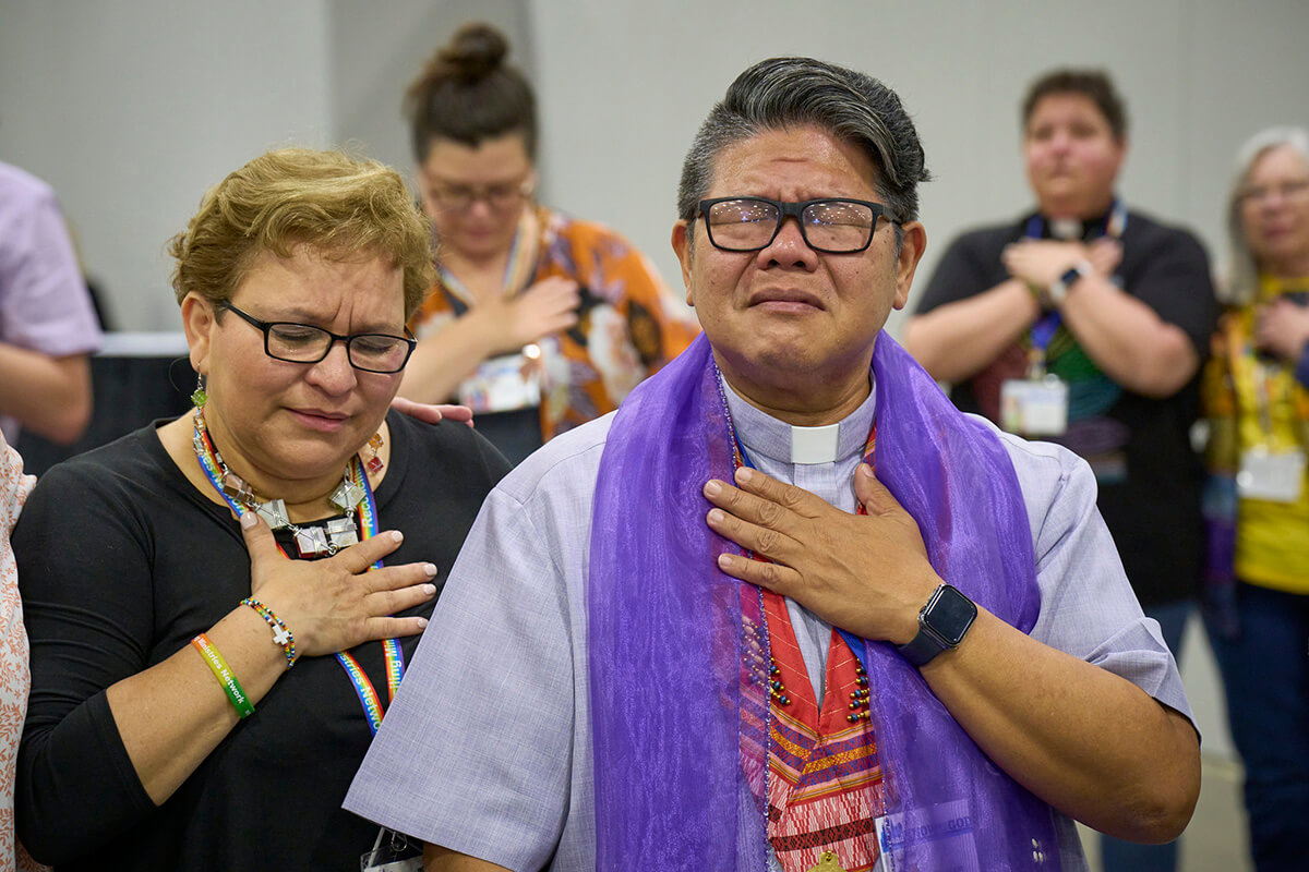 Révérend Izzy Alvaran na wengine wanalomba pamoja mnamo 1 mai baada ya Conférence Générale la Kanisa Méthodiste Unie huko Charlotte, Caroline du Nord, ilichagua kuondoa interdiction ya ordination ya wa clergés homosexuels — katazo ambalo limeanza tangu 1984. Picha na Paul Jeffrey, UM News.