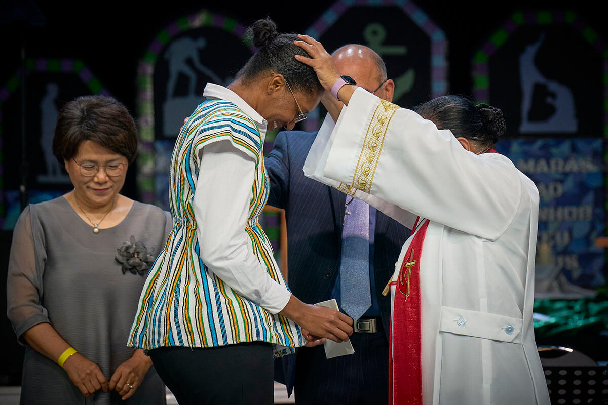 Askofu Ruby-Nell M. Estrella (droite) aki nommer Mamei Sombo Lansana kama missionaire wakati wa ibada ya asubuhi ya 2 mai ya Conférence Générale ya Kanisa la Méthodiste Unie huko Charlotte, Caroline du Nord. Wasaidizi ni Grace Choi na Roland Fernandes. Picha na Paul Jeffrey, UM News.