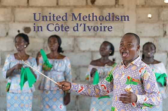 Edmond Assamoi directs the choir at the then newly opened United Methodist church in Gouabo, Côte d'Ivoire, in 2018. File photo by Mike DuBose, UM News.