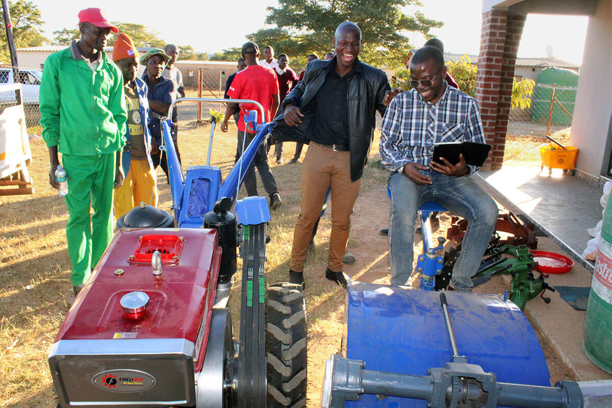 Morgan Jeranyama (right), Yambasu Agriculture Initiative national consultant in Zimbabwe, smiles as a hand tractor, trailer, plough and other supplies are delivered to the United Methodist Hanwa Mission in Macheke, Zimbabwe. Through the initiative, Global Ministries provided funding for the farming equipment, fencing and seedlings to support two greenhouses at the church mission. Photo by Kudzai Chingwe, UM News.