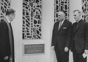 J. Edgar Hoover director del FBI, al centro junto a una placa con la que le dedicaron un gran vitral en la Iglesia Metodista Capitol Hill, hoy llamada Iglesia Metodista Unida Capitol Hill, el 26 de junio de 1966. También estan los reverendos Edward B. Lewis a la izquierda, pastor de la iglesia, y Frederick Brown Harris a la derecha, capellán del Senado. Está previsto que el vitral se vuelva a dedicar el 29 de septiembre para restar importancia a la conexión con Hoover, cuya antigua casa se encontraba en donde ahora está el estacionamiento de la iglesia. Foto cortesía de la Iglesia Metodista Unida Capitol Hill. J. Edgar Hoover director del FBI, al centro junto a una placa con la que le dedicaron un gran vitral en la Iglesia Metodista Capitol Hill, hoy llamada Iglesia Metodista Unida Capitol Hill, el 26 de junio de 1966. También estan los reverendos Edward B. Lewis a la izquierda, pastor de la iglesia, y Frederick Brown Harris a la derecha, capellán del Senado. Está previsto que el vitral se vuelva a dedicar el 29 de septiembre para restar importancia a la conexión con Hoover, cuya antigua casa se encontraba en donde ahora está el estacionamiento de la iglesia. Foto cortesía de la Iglesia Metodista Unida Capitol Hill.