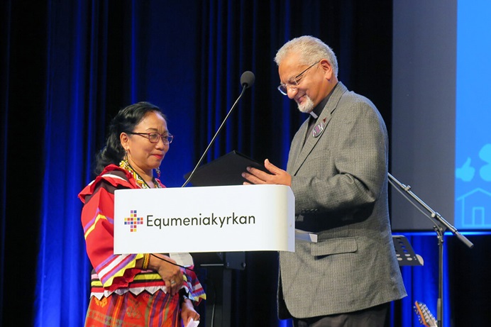 Norma P. Dollaga écoute l'évêque Ivan Abrahams lire la citation pour le Prix Méthodiste Mondial de la paix 2024 le 15 août pendant la Conférence Méthodiste Mondiale à Göteborg, en Suède. Mme Dollaga, diaconesse méthodiste unie, est récompensée pour ses efforts visant à mettre un terme aux exécutions extrajudiciaires aux Philippines. L'évêque méthodiste uni Christian Alsted a également reçu un prix de la paix pour son travail en Ukraine. Abrahams est le secrétaire général sortant du Conseil Méthodiste Mondial. Photo par Heather Hahn, UM News. Norma P. Dollaga écoute l'évêque Ivan Abrahams lire la citation pour le Prix Méthodiste Mondial de la paix 2024 le 15 août pendant la Conférence Méthodiste Mondiale à Göteborg, en Suède. Mme Dollaga, diaconesse méthodiste unie, est récompensée pour ses efforts visant à mettre un terme aux exécutions extrajudiciaires aux Philippines. L'évêque méthodiste uni Christian Alsted a également reçu un prix de la paix pour son travail en Ukraine. Abrahams est le secrétaire général sortant du Conseil Méthodiste Mondial. Photo par Heather Hahn, UM News.