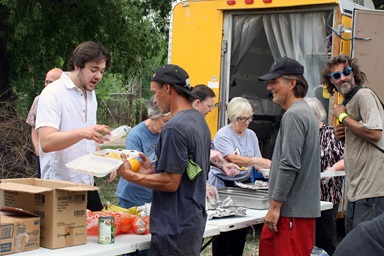Voluntarios/as de Ángeles de Hielo de la Primera Iglesia Metodista Unida en Moore, Oklahoma sirven almuerzo un miércoles de cada mes en un lote grande cerca del centro de la ciudad de Oklahoma. Iniciado por una pareja metodista unida, Ángeles de Hielo ha pasado de repartir agua a proporcionar alimentos y otros servicios a personas desamparadas. De izquierda a derecha están sirviendo Monty Bower, Gabriel Krows, Linda Dowling, Linda Starling y Jo Bower. Foto de Boyce Bowdon, Noticias MU. Voluntarios/as de Ángeles de Hielo de la Primera Iglesia Metodista Unida en Moore, Oklahoma sirven almuerzo un miércoles de cada mes en un lote grande cerca del centro de la ciudad de Oklahoma. Iniciado por una pareja metodista unida, Ángeles de Hielo ha pasado de repartir agua a proporcionar alimentos y otros servicios a personas desamparadas. De izquierda a derecha están sirviendo Monty Bower, Gabriel Krows, Linda Dowling, Linda Starling y Jo Bower. Foto de Boyce Bowdon, Noticias MU.