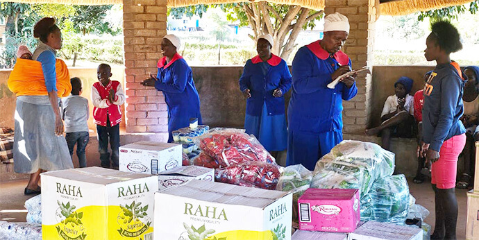 Les membres de l'Église Méthodiste Unie Ruwadzano Rwe et le personnel du Fairfield Children's Home supervisent la distribution de paniers de nourriture pour les enfants de l'orphelinat lié à l'Église Méthodiste Unie à Mutare, au Zimbabwe. La Class of 81 Charitable Foundation, dirigée par d'anciens élèves du lycée Hartzell, a fait don des fournitures. Photo par Tafadzwa Gumbochuma.