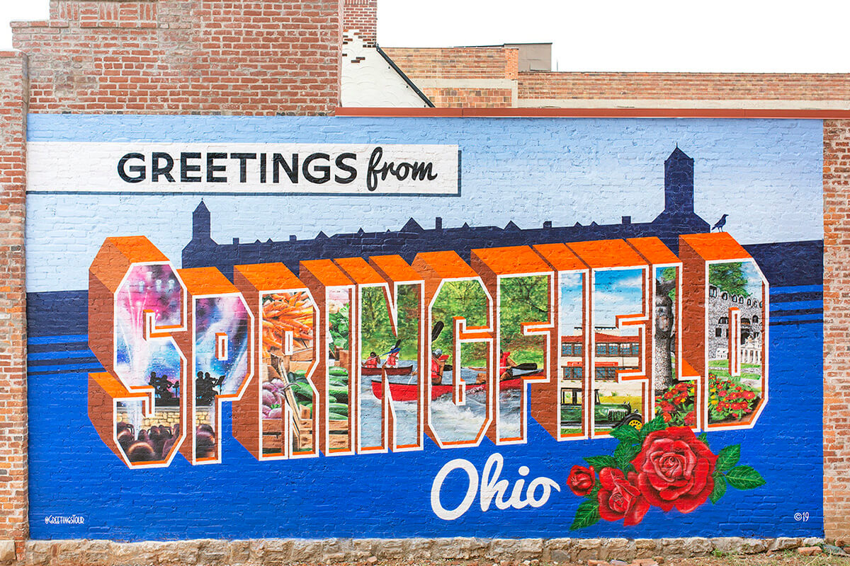 El mural Saludos desde Springfield, Ohio se ha convertido en un hito del centro de la ciudad. Los/as metodistas unidos/as en Ohio y más allá están dando un paso adelante para brindar una bienvenida similar y mostrar apoyo a los/as inmigrantes haitianos/as en la ciudad. Springfield experimentó más de 30 amenazas de bomba después de haber sido blanco de retórica antiinmigrante basada en afirmaciones falsas. Foto cortesía de Greetings Tour; usado con permiso.