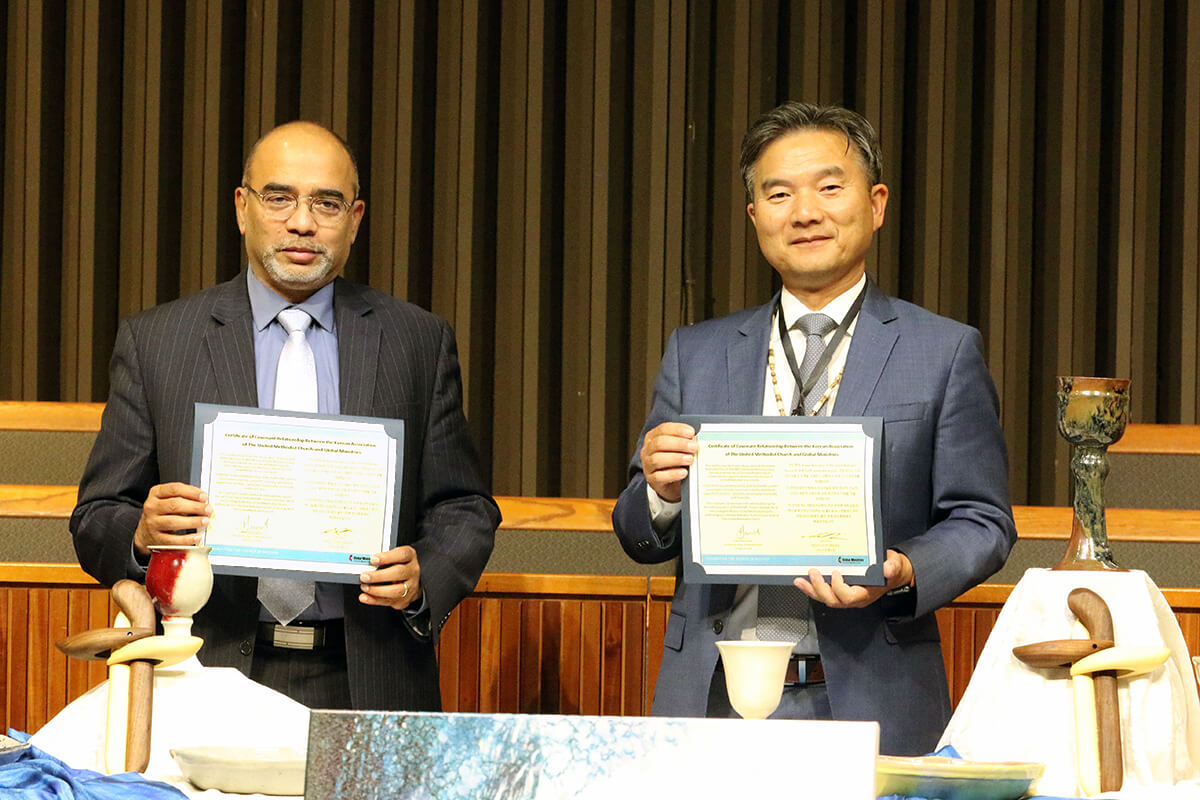 Roland Fernandes (left), top executive of the United Methodist Board of Global Ministries, and the Rev. Chang Min Lee, president of the Korean Association of The United Methodist Church, hold up a mission covenant they signed on Oct. 9 at Los Angeles Korean United Methodist Church during the association’s 2024 Convocation. The covenant is a commitment from Korean United Methodists to support 140 global missionaries financially for at least the next three years. Photo by the Rev. Thomas E. Kim, UM News.