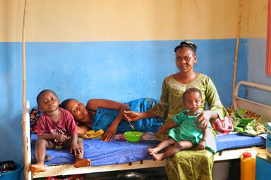 Pierre Kenga (non illustré) a parcouru plus de 80 kilomètres depuis le village de Dikwadjondo, dans la province de Sankuru, jusqu'à l'Hôpital Général de Tunda, affilié à l'Église Méthodiste Unie, à Tunda, au Congo, en compagnie de sa femme (assise) et de sa sœur (couchée). L'hôpital attire de plus en plus de patients de régions éloignées. Photo par Chadrack Tambwe Londe, UM News. Pierre Kenga (non illustré) a parcouru plus de 80 kilomètres depuis le village de Dikwadjondo, dans la province de Sankuru, jusqu'à l'Hôpital Général de Tunda, affilié à l'Église Méthodiste Unie, à Tunda, au Congo, en compagnie de sa femme (assise) et de sa sœur (couchée). L'hôpital attire de plus en plus de patients de régions éloignées. Photo par Chadrack Tambwe Londe, UM News.