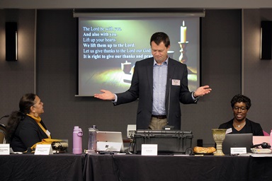 The Rev. Andy Call, chair of the General Conference commission, helps lead Holy Communion during opening worship Nov. 19 at the General Conference commission’s meeting in Charlotte, N.C. Sitting beside Call are Monalisa Tui'tahi (left), the commission’s vice chair, and the Rev. Aleze M. Fulbright (right), the new General Conference secretary. During the meeting, the commission began preparations for the next gathering of The United Methodist Church’s top lawmaking assembly, scheduled in 2028. Photo by Heather Hahn, UM News. The Rev. Andy Call, chair of the General Conference commission, helps lead Holy Communion during opening worship Nov. 19 at the General Conference commission’s meeting in Charlotte, N.C. Sitting beside Call are Monalisa Tui'tahi (left), the commission’s vice chair, and the Rev. Aleze M. Fulbright (right), the new General Conference secretary. During the meeting, the commission began preparations for the next gathering of The United Methodist Church’s top lawmaking assembly, scheduled in 2028. Photo by Heather Hahn, UM News.