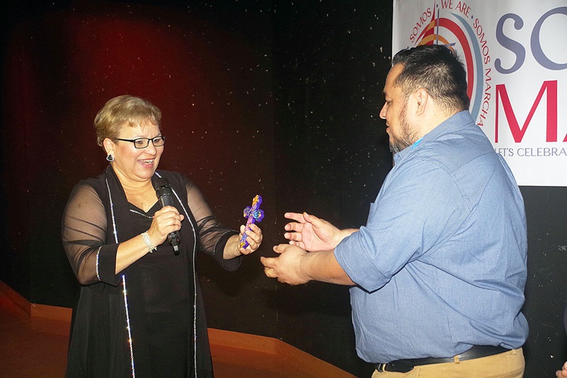 La Revda. Lysette Pérez, presidenta saliente de MARCHA hace un traspaso simbólico de la dirección de MARCHA al vicepresidente electo, Rev. Efraín Zavala, usando una cruz artesanal que simboliza la expresión de la identidad hispano-latina, rica y diversa, en sus diseños y colores. 