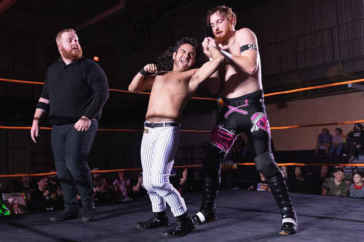 Rolando Perez (center) grimaces during a wrestling match with Jamesen Shook during a New South Pro Wrestling event Nov. 2 at the Priceville (Ala.) Event Center. Photo by Mike DuBose, UM News.
