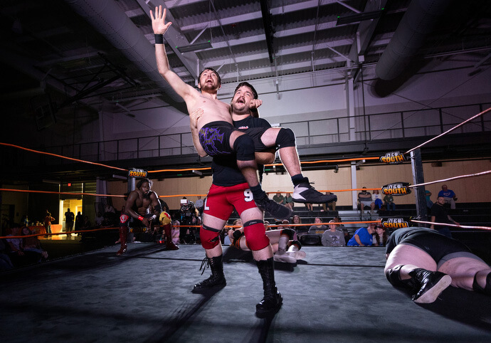 O lutador Negative Lee segura seu parceiro de dupla, Jake Franklin, no alto após uma vitória durante um evento da New South Pro Wrestling em 2 de novembro no Priceville (Ala.) Event Center.