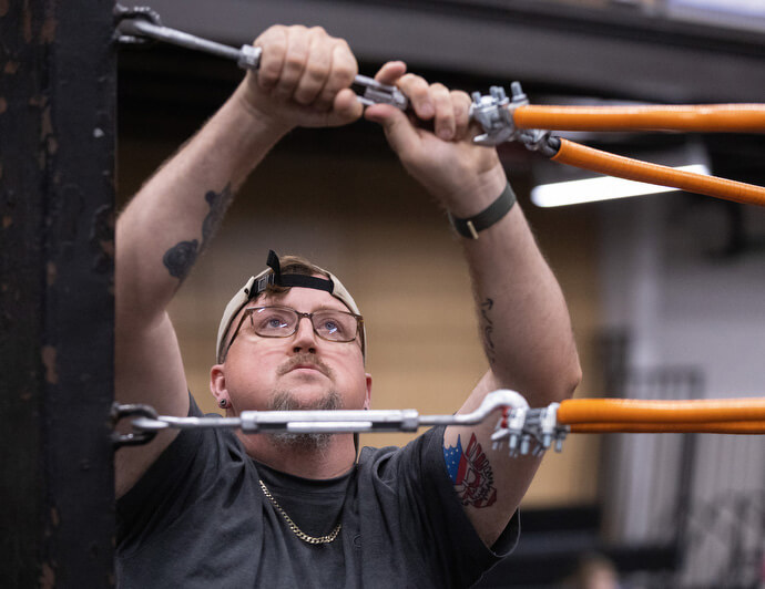 The Rev. Steven Barber helps disassemble the wrestling ring after a match at the Priceville Event Center.