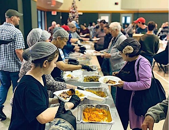 Voluntários servem os convidados para o jantar anual de Ação de Graças na IMU Klein.