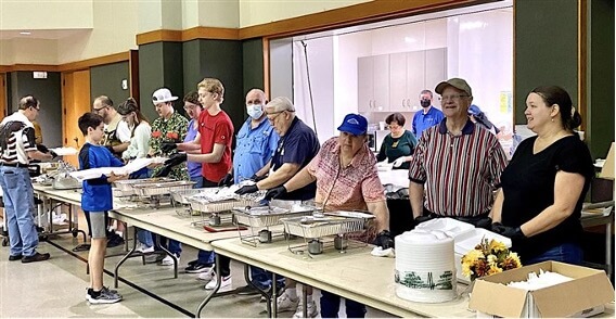 Voluntários servem os convidados para o jantar anual de Ação de Graças na IMU Klein.
