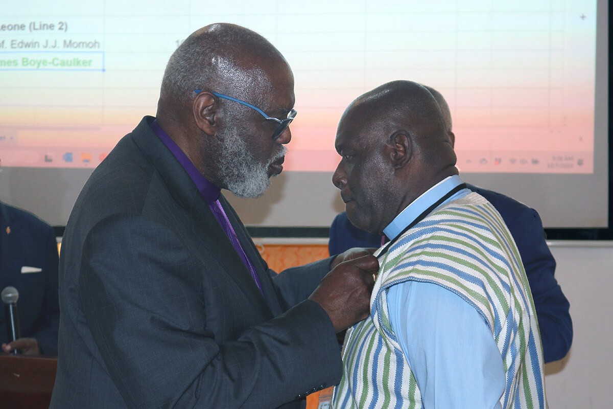 Retired Bishop Warner H. Brown (left), interim bishop of the Sierra Leone Area, bestows the episcopal pin on the Rev. James Boye-Caulker after he was elected bishop on Dec. 7 at The United Methodist Church’s West Africa Central Conference at the Best Western Premier Hotel in Accra, Ghana. Boye-Caulker, who has served as district superintendent of Sierra Leone’s Western District since 2016, was the second bishop elected at the Dec. 5-8 gathering. Photo by Eveline Chikwanah, UM News.