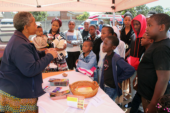 United Methodist Charity Kawadza (left) talks to children about cancer risks and routine health checks during a health expo hosted by The United Methodist Church’s Sunningdale Circuit in Harare, Zimbabwe. Kawadza works for Kidzcan, an organization that serves cancer patients up to age 18. Photo by Kudzai Chingwe, UM News.