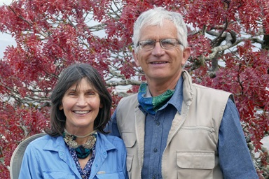 Larry e Jane Kies posam para uma fotografia em Vumba, uma das zonas cénicas nos arredores de Mutare, no Zimbabué. Atrás deles está uma árvore indígena do Zimbabué chamada Musasa. Como missionários Metodistas Unidos, o casal contribuiu para o desenvolvimento da agricultura e da educação no país na Missão da Igreja em Nyadire e na Universidade de África. Foto cedida por Larry Kies.