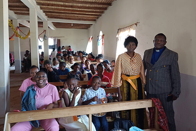 Les membres de l'église et de la communauté reçoivent de la nourriture pour la célébration de Noël à l'Église Méthodiste Unie de Ambodifasika. Photo par Esdras Rakotoarivony.