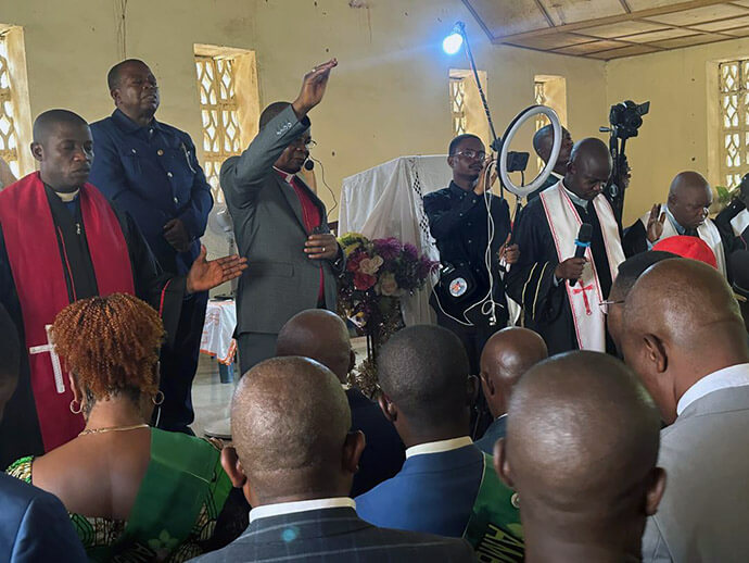 L'Évêque du Congo Est Gabriel Yemba Unda (la main levée) prie lors d'un service religieux en février. Mgr Unda est entouré d'ecclésiastiques d'autres confessions religieuses qui se sont unis pour appeler à la paix dans la région. Photo par Judith Osongo Yanga, UM News.