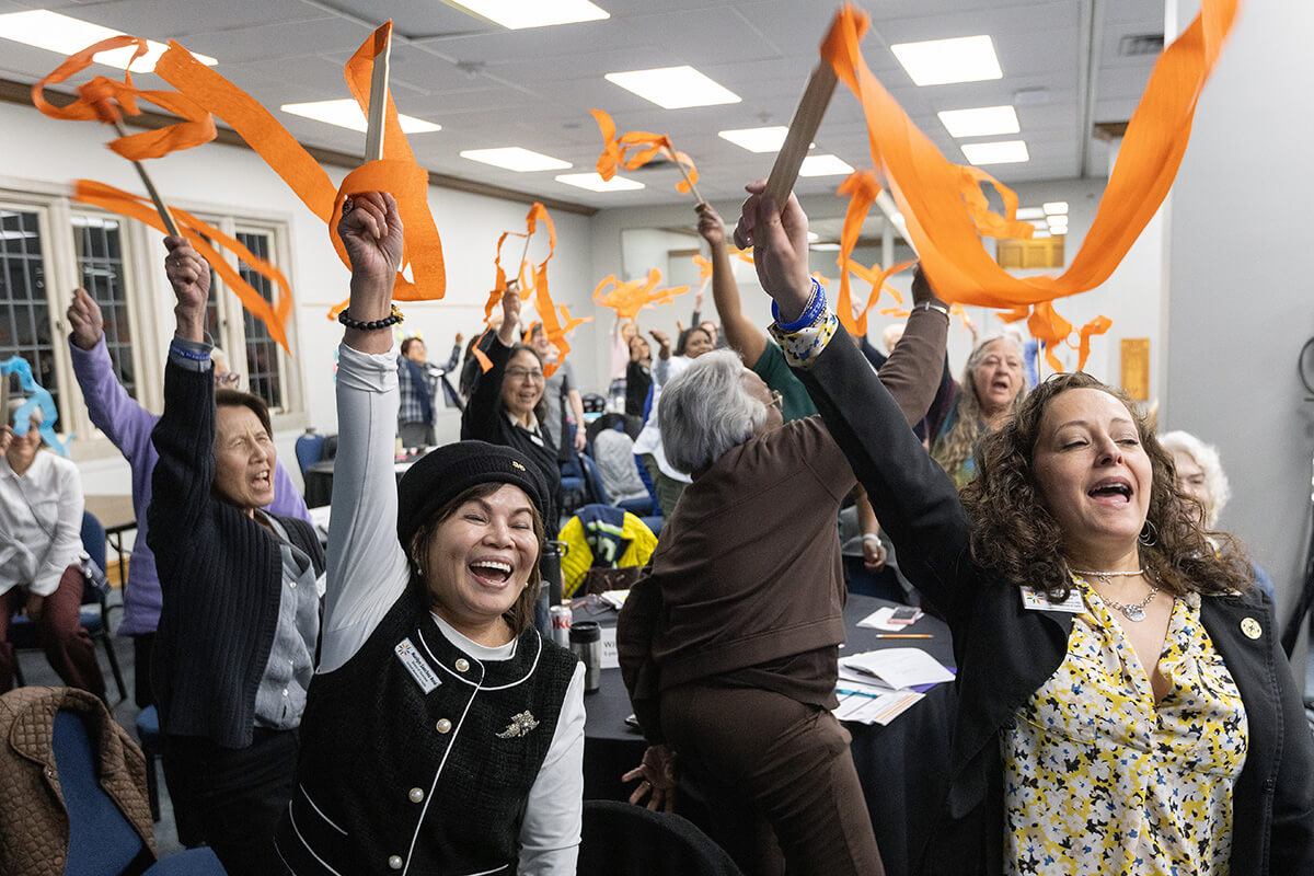 Miembros del Grupo Asesor del Programa Mujeres Unidas en la Fe celebran el anuncio de la Asamblea 2026, programada del 15 al 17 de mayo de 2026 en Indianápolis. La junta directiva y este grupo se reunieron en persona del 6 al 9 de marzo en el Centro Scarritt Bennett de Nashville, Tennessee, siendo esta la primera reunión presencial de la organización después del 2020. En primer plano aparecen Marilyn Sanchez Reid, de la Jurisdicción Occidental y miembro de la junta directiva, y la vicepresidenta Heidi Careaga, de la Jurisdicción NorCentral. Foto de Mike DuBose, Noticias MU.
