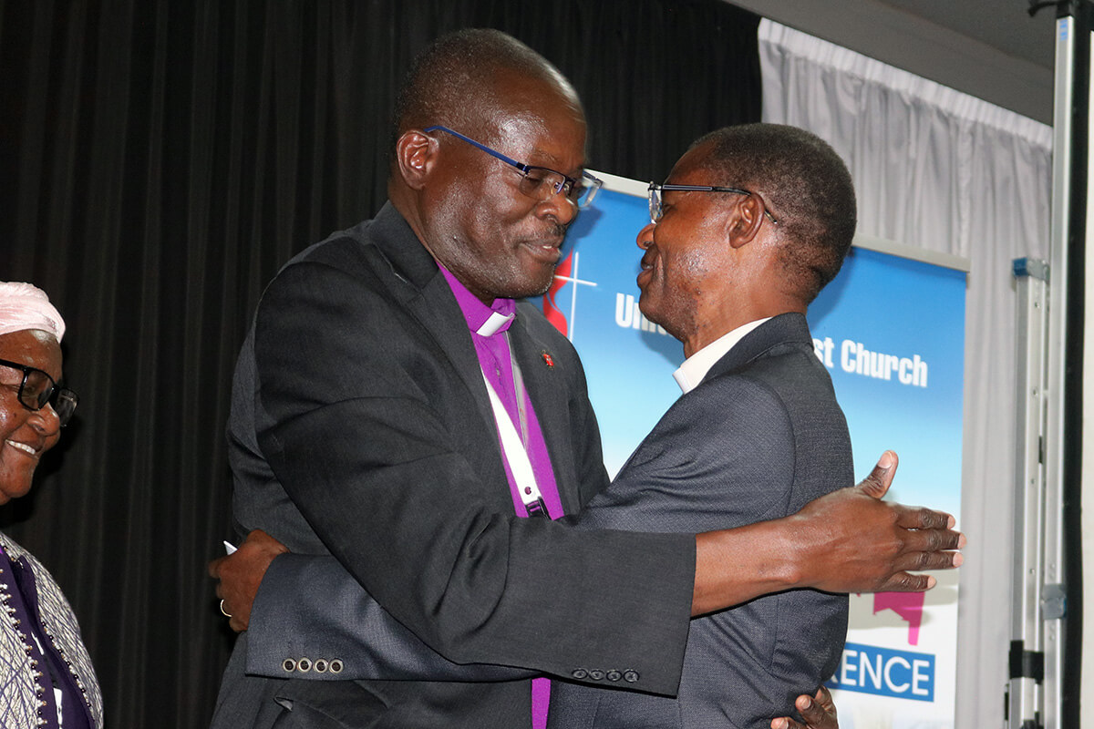 Bishop Daniel Wandabula (left), Africa Central Conference College of Bishops president, congratulates the Rev. Emmanuel Sinzohagera of Burundi after he was elected a United Methodist bishop on the first ballot March 15 at the Africa Central Conference in Johannesburg. At left, Bishop Joaquina F. Nhanala of the Mozambique Episcopal Area looks on. Photo by Eveline Chikwanah, UM News.