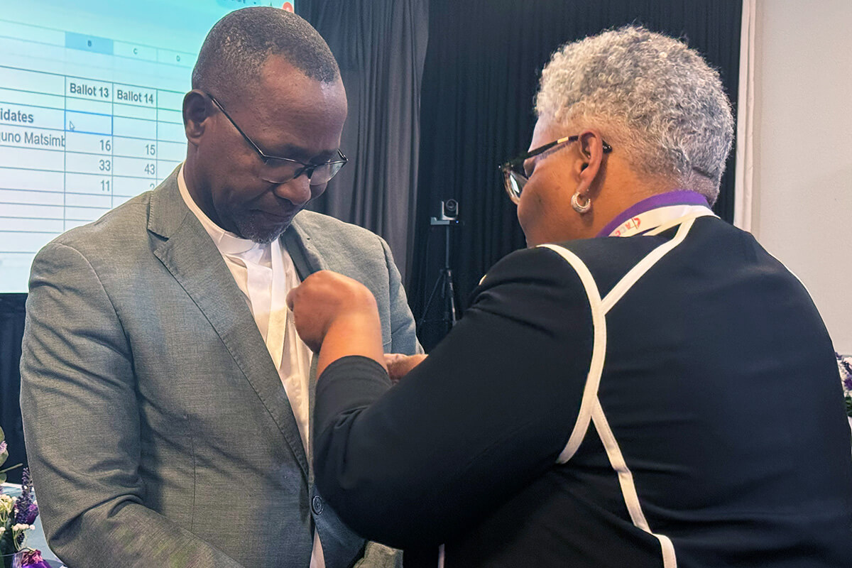 The Rev. João Filimone Sambo of Mozambique receives the United Methodist  episcopal pin from Bishop LaTrelle Easterling. Sambo was elected bishop March 15 by the Africa Central Conference. Photo by Priscilla Muzerengwa, United Methodist Communications.