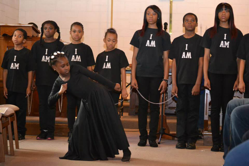 Young people at the St. Mark Youth and Family Center perform a dance with “I am” emblazoned on their T-shirts, both a reference to the biblical name of God and an expression of their own personal existence. File photo courtesy of St. Mark United Methodist Church.