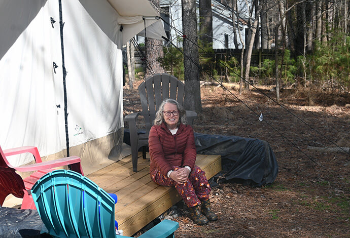 The Rev. Elaine A. Heath, an ordained United Methodist elder, sits in front of a tent pitched at Spring Forest, a bucolic property that is the site of a community working together to live a Christian lifestyle. Heath says her vocation and founding of Spring Forest are part of her recovery journey from multiple forms of trauma. Photo by Jim Patterson, UM News.