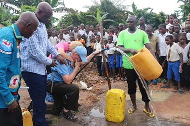 Le révérend Jonathan Baker et Donna Baker sont bouleversés par l'eau qui jaillit d'un puits à Wembo Nyama, en République démocratique du Congo, en 2016. La population locale priait pour avoir de l'eau depuis des décennies. L'église méthodiste unie New Covenant de The Villages (Floride) et son campus Lake Deaton United Methodist Church de Wildwood (Floride) ont collecté les fonds nécessaires à la construction de ce premier puits dans la province de Sankuru, au Congo central. Photo du révérend Jim Divine.