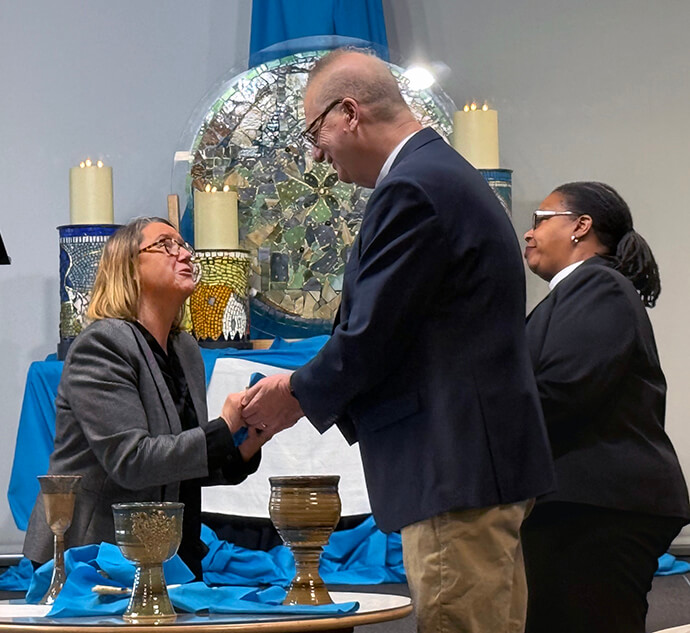 The Rev. Beth Crissman (left), director of the Peace Conference, clasps hands with Western North Carolina Conference Bishop Ken Carter during the gathering’s closing worship as Bishop Robin Dease looks on. Carter helped with planning and spoke throughout the conference. Dease, bishop of the North Georgia and South Georgia conferences, led the closing worship service on April 6. Photo by Crystal Caviness, United Methodist Communications.