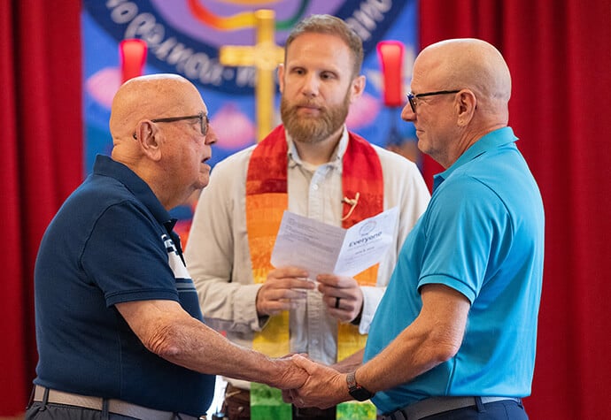 The Rev. Deen Thompson (left) and John Brown renew their wedding vows before the Rev. Eric Mayle at Edgehill United Methodist Church in Nashville, Tenn. Photo by Mike DuBose, UM News.