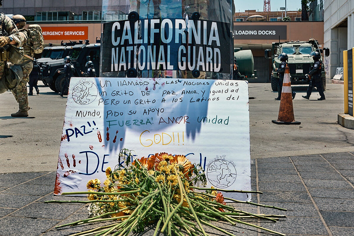A National Guardsman stands watch at a June 10 prayer vigil organized by the United Methodist-founded Clergy and Laity United for Economic Justice in downtown Los Angeles. The participants placed in front of him a poster in Spanish calling for peace, love and equality and asking for support. United Methodists across the Los Angeles area are working to stand up for immigrant rights while trying to de-escalate a tense situation as the Trump administration has deployed National Guard troops and Marines to quell protests against U.S. Immigration and Customs Enforcement. Photo courtesy of Clergy and Laity United for Economic Justice.