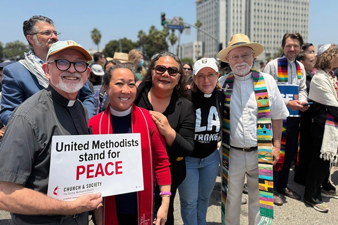 De gauche à droite, le révérend Frank Wulf, la révérende Allison Mark, Monalisa Tui'tahi, la révérende Hannah Adair Bonner et le révérend David Farley posent pour une photo lors d'une veillée devant le bâtiment fédéral de Los Angeles, le 9 juin, afin de prier pour les immigrés détenus à l'intérieur. L'évêque Dottie Escobedo-Frank de la Conférence Californie-Pacifique était également présent. Les Ministères Méthodistes Unis, y compris le Conseil Des Évêques et le Conseil méthodiste uni de l'Église et de la Société, font partie des 215 organisations non gouvernementales qui ont reçu une lettre d'une commission du Congrès sondant leurs ministères auprès des communautés d'immigrés. Mark est président de Church and Society. Photo avec l'aimable autorisation de la Conférence de Californie-Pacifique.  De gauche à droite, le révérend Frank Wulf, la révérende Allison Mark, Monalisa Tui'tahi, la révérende Hannah Adair Bonner et le révérend David Farley posent pour une photo lors d'une veillée devant le bâtiment fédéral de Los Angeles, le 9 juin, afin de prier pour les immigrés détenus à l'intérieur. L'évêque Dottie Escobedo-Frank de la Conférence Californie-Pacifique était également présent. Les Ministères Méthodistes Unis, y compris le Conseil Des Évêques et le Conseil méthodiste uni de l'Église et de la Société, font partie des 215 organisations non gouvernementales qui ont reçu une lettre d'une commission du Congrès sondant leurs ministères auprès des communautés d'immigrés. Mark est président de Church and Society. Photo avec l'aimable autorisation de la Conférence de Californie-Pacifique.