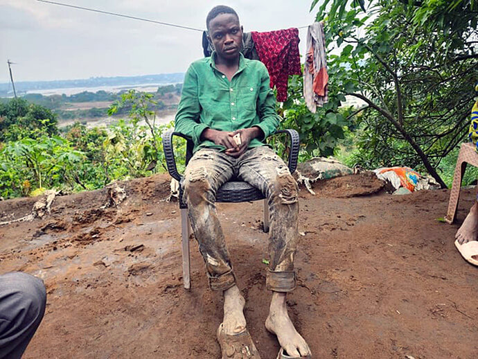 Raphael Ayakundu, a young United Methodist choir member and flood survivor, sits in front of what remains of his home in Ngaliema. Like many affected families, he bears witness to the distress and precariousness of the survivors after the disaster that struck the capital. Photo by Rev. Fiston Okito, UM News.