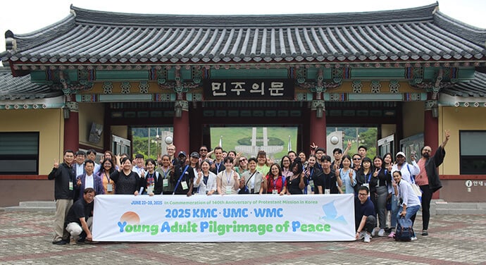 The 2025 Young Adults Pilgrimage of Peace participants stand in front of the Democracy Gate of the May 18 Memorial Park in Gwangju, South Korea, on June 24. On May 18, 1980, the South Korean military violently suppressed nonviolent student demonstrations against the military dictatorship that seized power the previous year. Photo by the Rev. Thomas E. Kim, UM News.