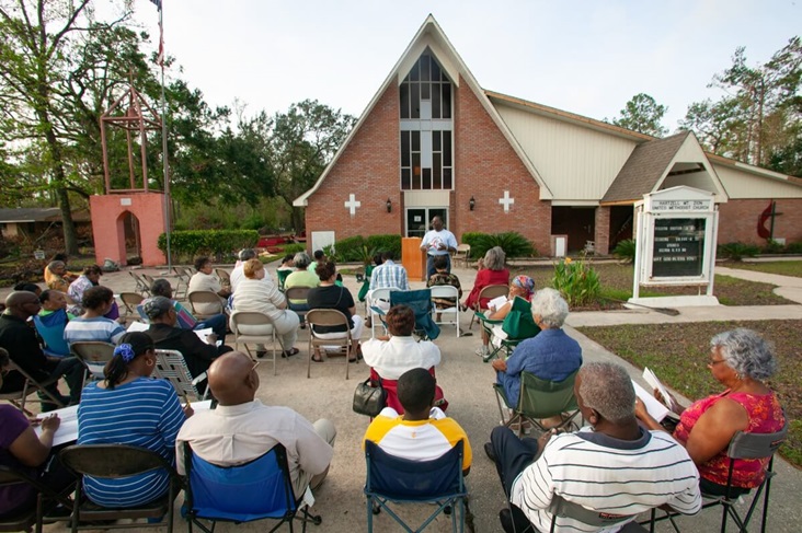 Members of Hartzell Mt. Zion United Methodist Church in Slidell, La., gather for an outdoor worship service following Hurricane Katrina. The church’s sanctuary was ruined by the storm surge from the hurricane. A UMNS photo by Mike DuBose. Photo # 05H141. Accompanies UMNS story #534. 9/26/05